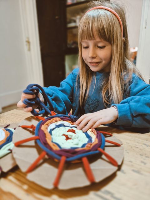 A child building a mandala from found objects