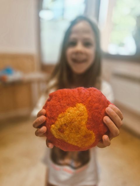 A child holding a finished felted piece